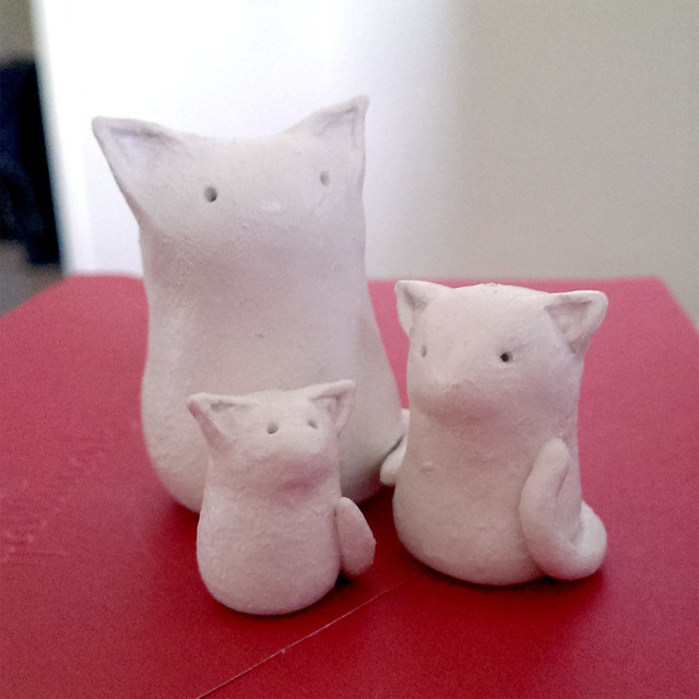 a trio of tiny ceramic cats