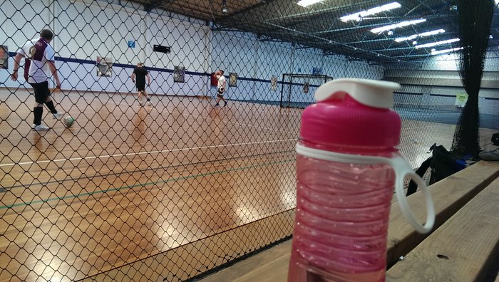 a pink drink bottle beside a futsal court