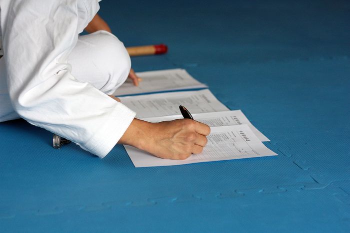 Sensei filling out a grading sheet