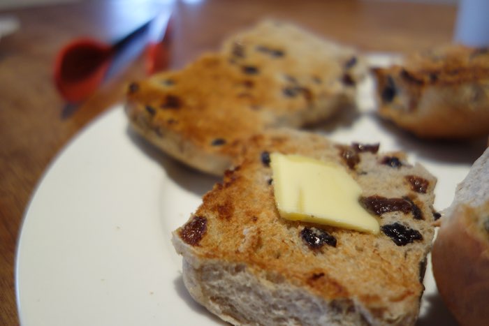 butter on a toasted hot cross bun