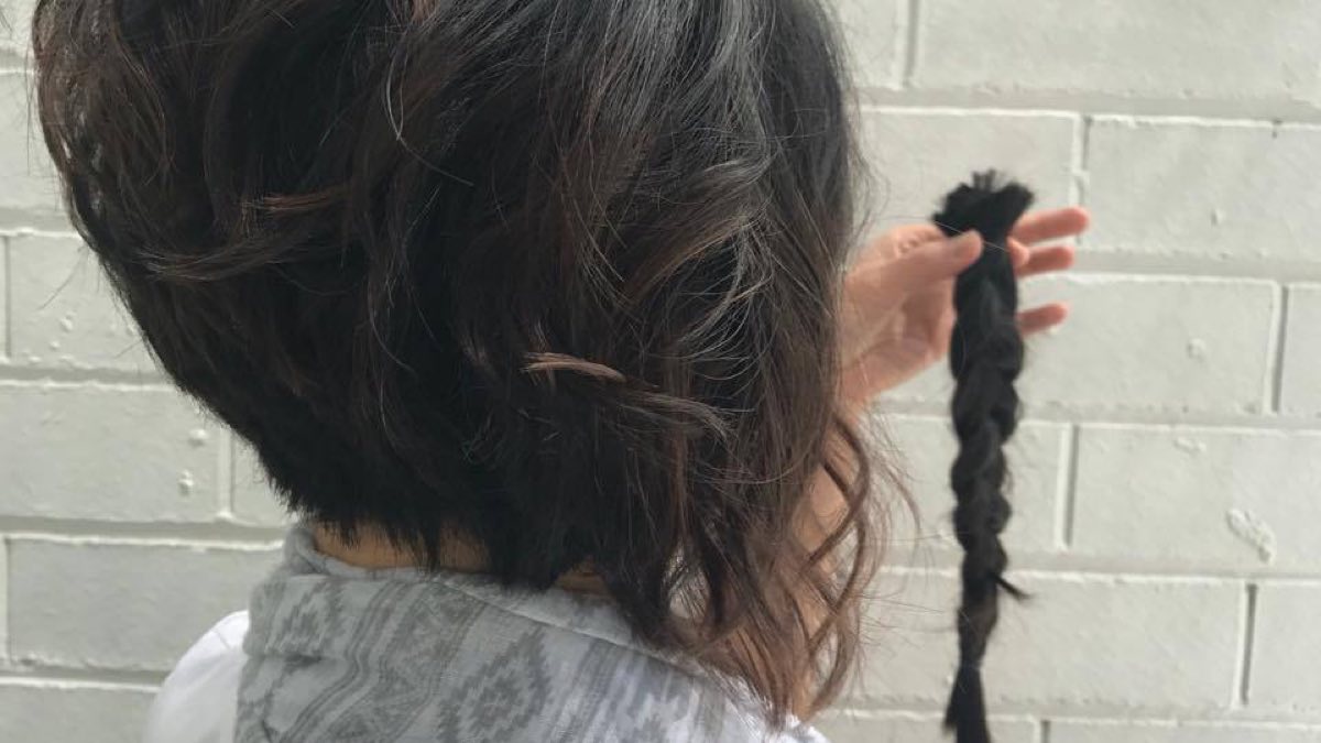 back view of my new short choppy haircut as I hold up my braided lock of hair